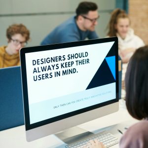 Group of designers collaborating in modern office space with computer.